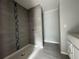 Bathroom features a modern tiled shower with decorative accent stripe and updated vanity with granite countertop at 28 Bahia Pass Dr, Ocala, FL 34472