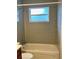 This bathroom has a shower-tub combo, tile walls, and a window at 2848 Se 11Th St, Ocala, FL 34471