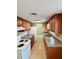 Galley kitchen featuring wood cabinets, granite countertops, and white appliances at 2848 Se 11Th St, Ocala, FL 34471