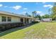 Backyard with green lawn, mature bushes and trees, as well as a storage shed at 3950 Se 10Th Ln, Ocala, FL 34471