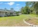 Wide backyard showcasing a well-kept lawn, partial fencing, and mature trees at 3950 Se 10Th Ln, Ocala, FL 34471