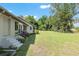 Expansive backyard featuring a well-maintained lawn, mature trees, and partial fencing at 3950 Se 10Th Ln, Ocala, FL 34471