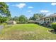 Open backyard featuring lush grass, mature trees, shed and view of the home at 3950 Se 10Th Ln, Ocala, FL 34471
