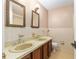 Bathroom with dual sinks, a wooden vanity, and a toilet at 3950 Se 10Th Ln, Ocala, FL 34471