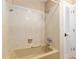 Bathroom features a shower and tub with neutral-toned tiling and white doors at 3950 Se 10Th Ln, Ocala, FL 34471