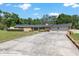 Traditional brick home with a sprawling driveway, two-car garage, and lush, tree-lined surroundings at 3950 Se 10Th Ln, Ocala, FL 34471