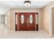 Grand foyer with beautiful double doors, tile flooring, and neutral wall colors at 3950 Se 10Th Ln, Ocala, FL 34471
