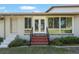 Charming front entrance of a house with brick stairs, railing, and large windows that provide natural light at 3950 Se 10Th Ln, Ocala, FL 34471