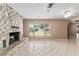 Living room showcasing a stone fireplace, neutral walls, tile floors, and natural light at 3950 Se 10Th Ln, Ocala, FL 34471