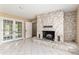Living room with stone fireplace, tile floors, and access to outdoor patio via double doors at 3950 Se 10Th Ln, Ocala, FL 34471