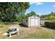 Backyard storage shed with double doors and a concrete patio at 3950 Se 10Th Ln, Ocala, FL 34471