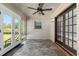 An outdoor sunroom with tile flooring, ceiling fan, windows and french doors for indoor outdoor living at 3950 Se 10Th Ln, Ocala, FL 34471