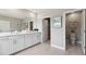 Bright bathroom featuring a double vanity, large mirror, neutral color palette, and separate toilet room at 4317 Sw 54Th Street Rd, Ocala, FL 34474