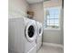 Convenient laundry room with modern washer and dryer, shelving, and a bright window at 4317 Sw 54Th Street Rd, Ocala, FL 34474