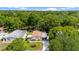 Aerial view featuring a home with green lawn, palm tree, and mature trees at 514 Saint Andrews Blvd, Lady Lake, FL 32159