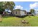 Backyard featuring a well-manicured lawn, garden beds, and a covered patio with outdoor furniture at 514 Saint Andrews Blvd, Lady Lake, FL 32159