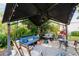 Relaxing covered outdoor patio with comfortable seating, decor, and views of the lush, green yard at 514 Saint Andrews Blvd, Lady Lake, FL 32159
