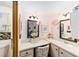 Bathroom featuring a pink accent wall, matching framed mirrors, and a sink with ample counter space at 514 Saint Andrews Blvd, Lady Lake, FL 32159