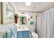 Charming bathroom with blue vanity, coastal decor, and shower with striped curtain at 514 Saint Andrews Blvd, Lady Lake, FL 32159