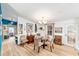 Well-lit dining room featuring a modern chandelier, glass-top table, and view into the bedrooms at 514 Saint Andrews Blvd, Lady Lake, FL 32159