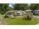 Well-maintained home with a lush lawn, palm trees, and a cozy screened-in porch at 514 Saint Andrews Blvd, Lady Lake, FL 32159