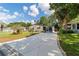 Attractive home showcasing a long driveway, well-kept lawn, and a charming front porch with outdoor seating at 514 Saint Andrews Blvd, Lady Lake, FL 32159