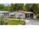 Inviting single-story home with a lush green lawn, complemented by mature trees and a stately American flag at 514 Saint Andrews Blvd, Lady Lake, FL 32159