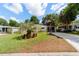 Charming home featuring a well-manicured lawn, palm trees, and a welcoming front porch at 514 Saint Andrews Blvd, Lady Lake, FL 32159
