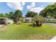 Well-maintained lawn with a charming home featuring a delightful garden and mature trees in a tranquil setting at 514 Saint Andrews Blvd, Lady Lake, FL 32159