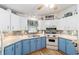 Charming kitchen with blue and white cabinetry, modern appliances, and stylish backsplash at 514 Saint Andrews Blvd, Lady Lake, FL 32159
