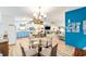 Bright, open living space featuring a round glass-top table, blue accent wall, and updated kitchen at 514 Saint Andrews Blvd, Lady Lake, FL 32159