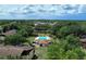 Aerial view of community pool surrounded by lush trees and buildings at 519 Fairways Cir # A, Ocala, FL 34472