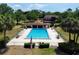 Aerial view of community pool showcasing the clear blue water, surrounding greenery and a lounge area at 519 Fairways Cir # A, Ocala, FL 34472
