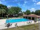 Community pool area with lounge chairs, umbrellas, and a covered pavilion set among well-maintained grounds at 519 Fairways Cir # A, Ocala, FL 34472