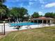 Community pool with crystal clear water surrounded by lounge chairs, umbrellas, and a shaded pavilion at 519 Fairways Cir # A, Ocala, FL 34472