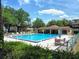 Community pool featuring clear blue water with poolside chairs, umbrellas, and a shaded structure for leisure at 519 Fairways Cir # A, Ocala, FL 34472