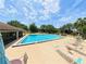 Community pool with lounge chairs and umbrellas, and surrounding buildings at 519 Fairways Cir # A, Ocala, FL 34472