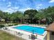 Community pool featuring lounge chairs, tables and umbrellas near lush landscaping and buildings at 519 Fairways Cir # A, Ocala, FL 34472