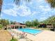 Community pool with lounge chairs, tables and umbrellas, and surrounding landscaping and buildings at 519 Fairways Cir # A, Ocala, FL 34472