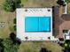 Aerial view of a community pool and lounge chairs next to a clubhouse and well-maintained grounds at 519 Fairways Cir # A, Ocala, FL 34472