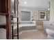 Bright bathroom featuring tiled walls, a garden tub, and a modern vanity at 530 Sw 35Th St, Ocala, FL 34471