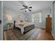 Bedroom with pale blue walls, a ceiling fan, a window and hardwood floors covered with a rug at 530 Sw 35Th St, Ocala, FL 34471