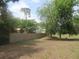 Large fenced backyard featuring mature trees and green grass at 5949 Se 164Th Ct, Ocklawaha, FL 32179