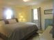 Bright bedroom featuring windows, a comfortable bed, and a charming green lamp at 5949 Se 164Th Ct, Ocklawaha, FL 32179