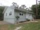 Well-maintained single-story home with a neutral color scheme, landscaped yard, and mature trees at 5949 Se 164Th Ct, Ocklawaha, FL 32179