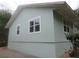 Side view of the home with a neutral color scheme, and several windows at 5949 Se 164Th Ct, Ocklawaha, FL 32179