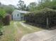 Exterior view showing driveway with green lawn and mature shrubs at 5949 Se 164Th Ct, Ocklawaha, FL 32179