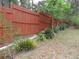 A view of the property line with a privacy fence and bromeliads at 5949 Se 164Th Ct, Ocklawaha, FL 32179