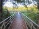 Picturesque view of a fishing pier extending over the water, surrounded by lush greenery and trees at 5949 Se 164Th Ct, Ocklawaha, FL 32179