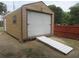 Exterior view of a detached garage with a rolling door and a ramp at 5949 Se 164Th Ct, Ocklawaha, FL 32179